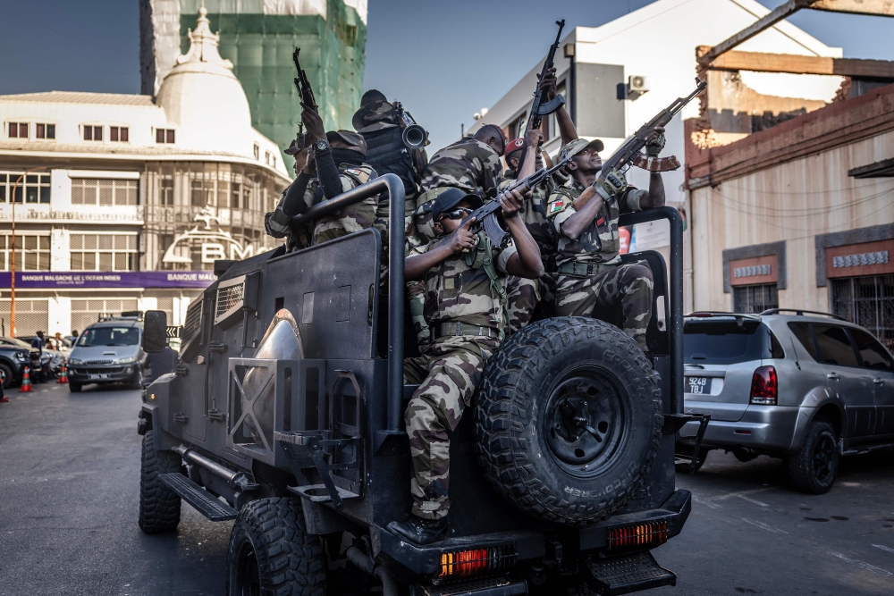 Members of Madagascar’s Army CAPSAT unit ride in armoured vehicles while assuming a defensive posture as they leave the Presidential Palace in Antananarivo, October 14, 2025. (Photo by Luis Tato / AFP)