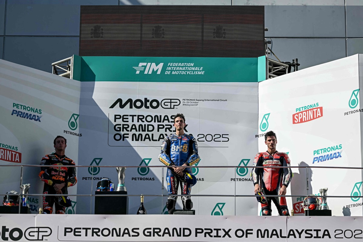 BK8 Gresini Racing MotoGP team's Spanish MotoGP rider Alex Marquez (C) celebrates on the podium after winning the MotoGP Malaysian Grand Prix with second-placed Red Bull KTM Factory Racing team's Spanish MotoGP rider Pedro Acosta (L) and third-placed Honda HRC Castrol team's Spanish MotoGP rider Joan Mir (R) at the Sepang International Circuit in Sepang on October 26, 2025. (Photo by Lillian SUWANRUMPHA / AFP)