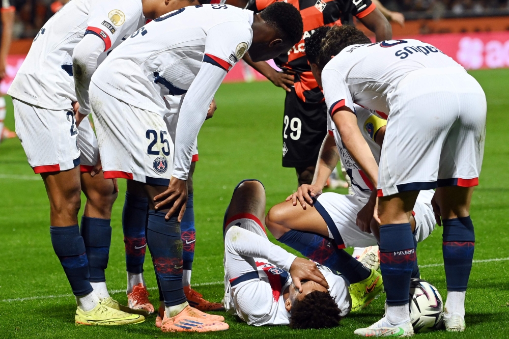 Paris Saint-Germain's French midfielder Desire Doue reacts in pain after suffering an injury during the French L1 football match between FC Lorient and Paris Saint-Germain (PSG) at the Stade du Moustoir in Lorient, western France, on October 29, 2025. (Photo by Jean-Francois Monier / AFP)

