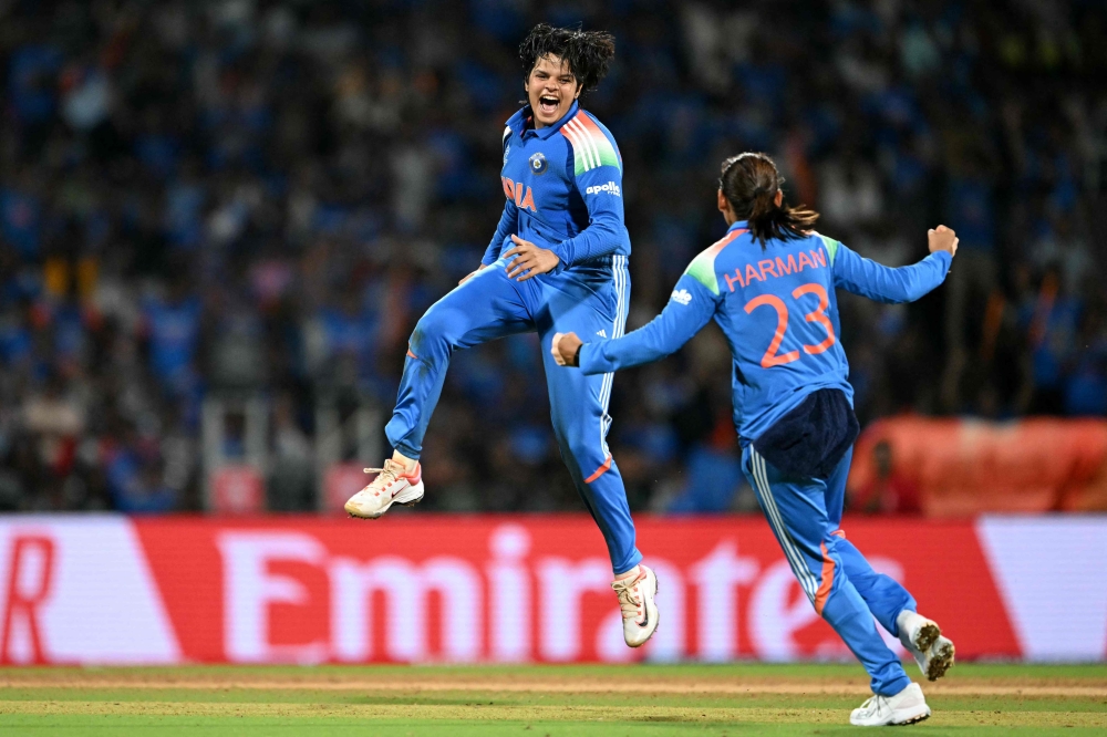 India's Shafali Verma (L) celebrates with her team captain Harmanpreet Kaur after taking the wicket of South Africa's Marizanne Kapp at the DY Patil Stadium in Navi Mumbai on November 2, 2025. (Photo by Punit Paranjpe / AFP)