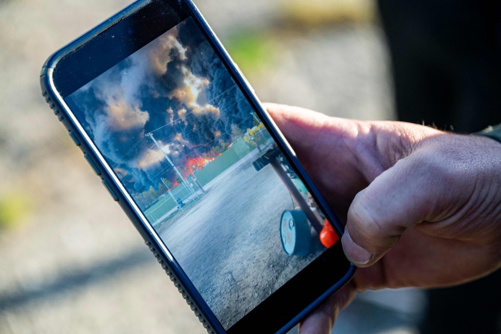 An employee of Kentucky Truck Parts and Services shows a phone video that was taken after a UPS MD-11 cargo plane crashed on November 5, 2025. Michael Swensen/Getty Images/AFP 