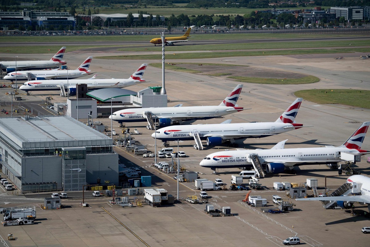 British Airways jets are seen parked on the tarmac at Heathrow Airport on June 13, 2021, in west London. Photo by Brendan Smialowski / AFP
