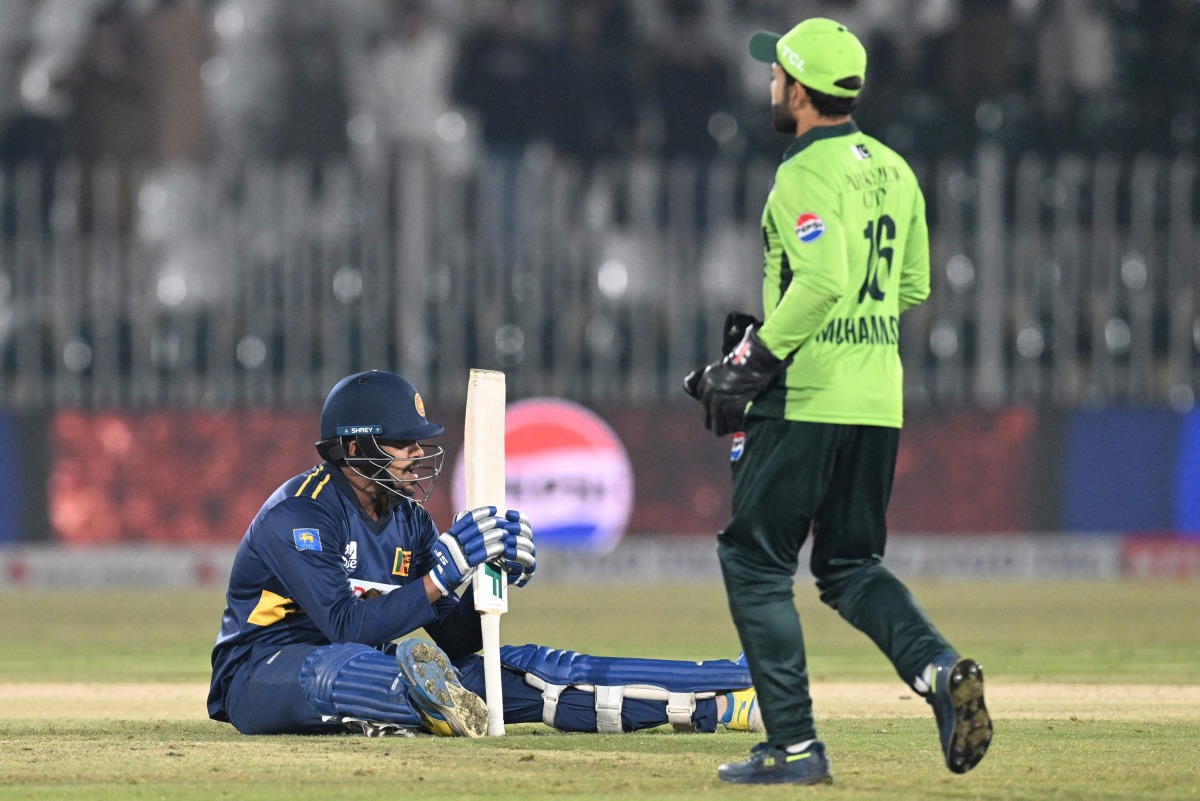Sri Lanka's Maheesh Theekshana (L) reacts at at the end of the first one-day international (ODI) cricket match between Pakistan and Sri Lanka at the Rawalpindi Cricket Stadium in Rawalpindi on November 11, 2025. (Photo by Aamir QURESHI / AFP)