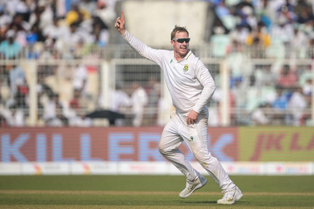South Africa's Simon Harmer celebrates after taking the wicket of India's Kuldeep Yadav at the Eden Gardens in Kolkata on November 16, 2025. (Photo by Dibyangshu Sarkar / AFP) 