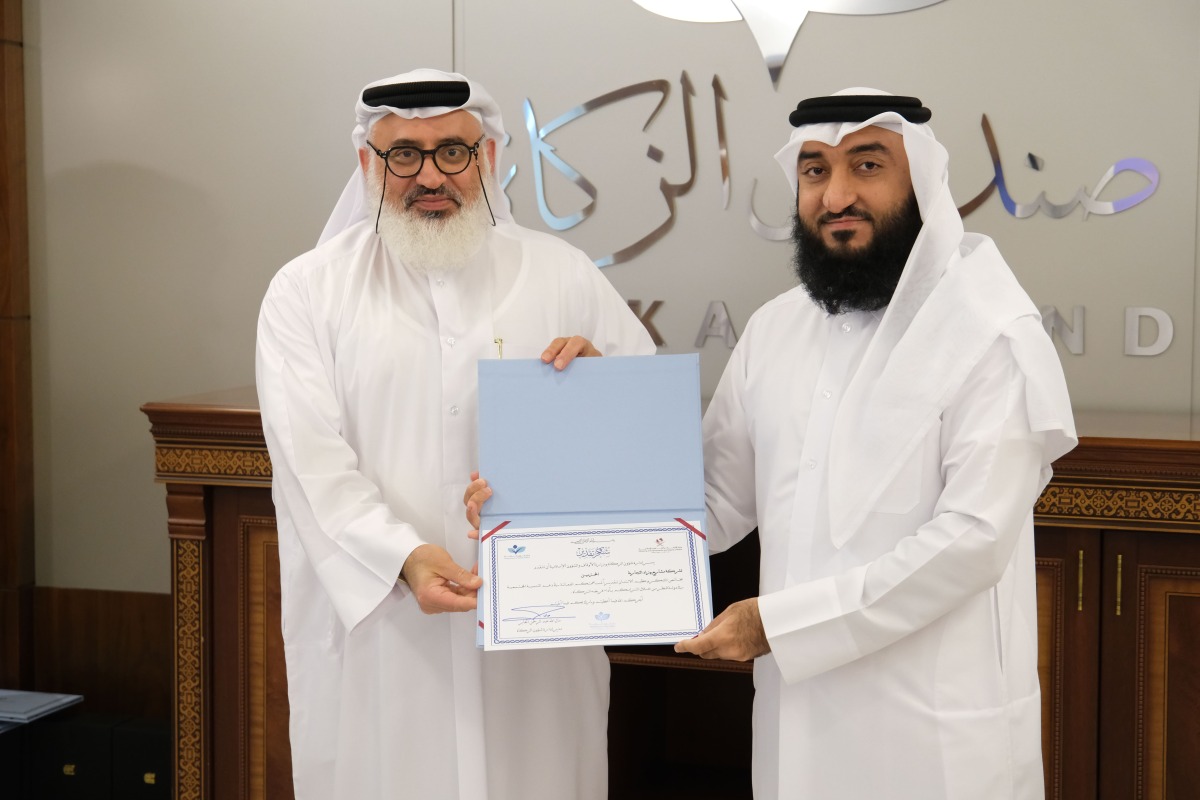 Director of the Zakat Affairs Department MalAllah Abdulrahman Al Jaber (right) honouring a company representative.