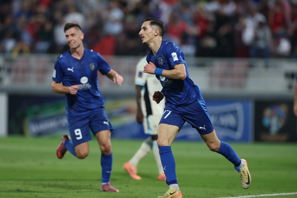 Al Duhail's Adil Boulbina (right) celebrates with teammate Krzysztof Piatek after scoring a goal.