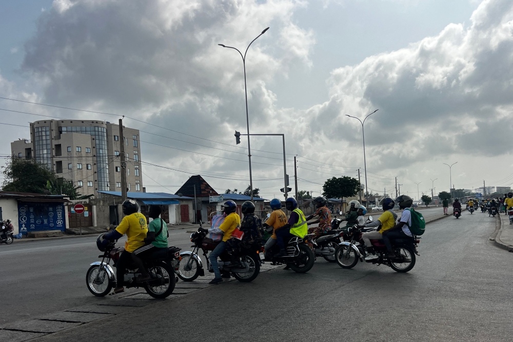 Motorbike taxis carrying passengers stops at a crossroad in Cotonou following rumors of a possible coup in the country on December 7, 2025. (Photo by AFP)
 