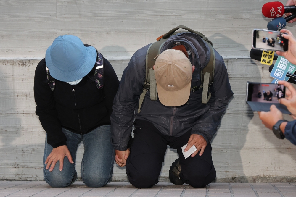 This picture taken and released by Taiwan's Central News Agency (CNA) on December 23, 2025, shows the parents of the suspect in the December 19 Taipei metro stabbings. (Photo by Weng Rui Kun / Central News Agency (CNA) / AFP)