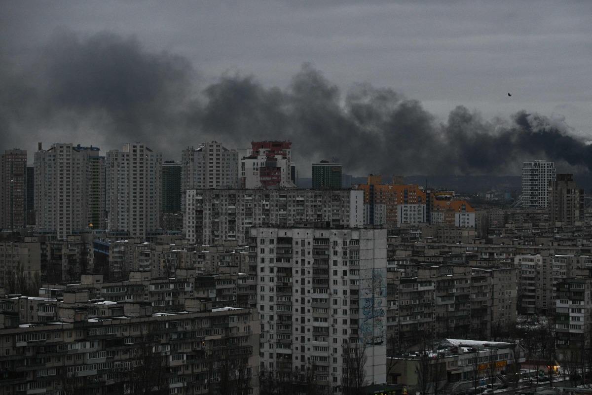 This photograph taken on December 27, 2025 shows smoke rising above residential buildings following Russian drones and missiles attack, in Kyiv, amid the Russian invasion in Ukraine. Photo by AFP