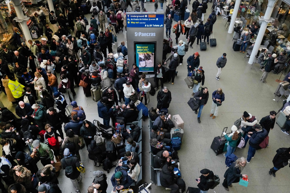 Travellers are pictured at St. Pancras station in London on December 30, 2025, as Eurostar train service between Britain and continental Europe is halted. Eurostar advised passengers to postpone their journeys to a later date, citing 