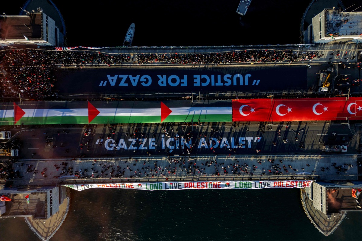 This aerial picture shows thousands of people demonstrating their solidarity with the Palestinian people at the Galata Bridge in Istanbul on January 1, 2026. (Photo by Yasin AKGUL / AFP)
