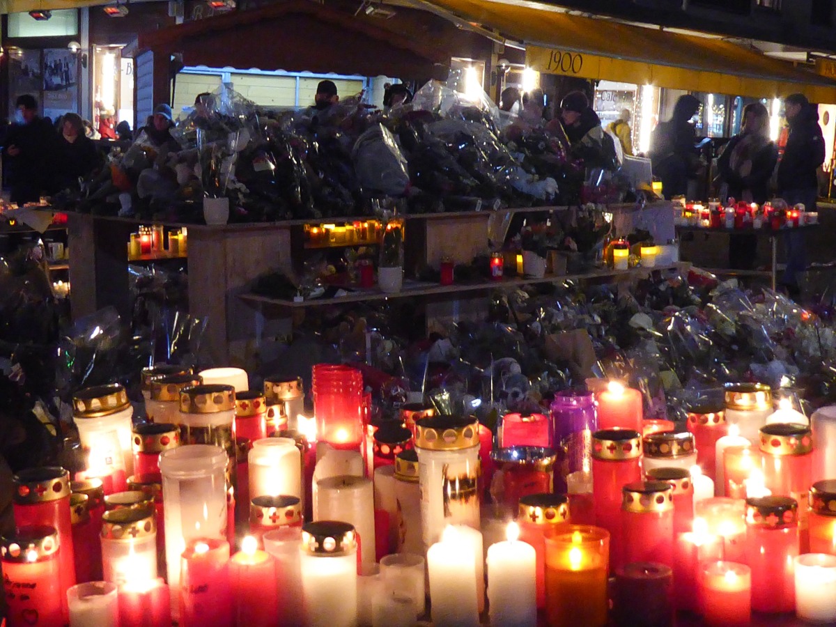 Candles and flowers are displayed at a makeshift memorial following a fire at 