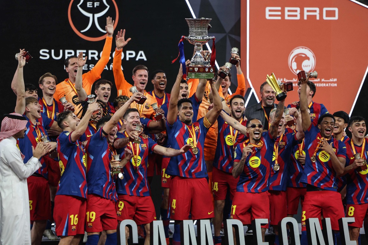 Barcelona's players raise the trophy as they celebrate after winning the Spanish Super Cup final football match between FC Barcelona and Real Madrid at the King Abdullah Stadium in Jeddah on January 11, 2026. (Photo by Fadel SENNA / AFP)