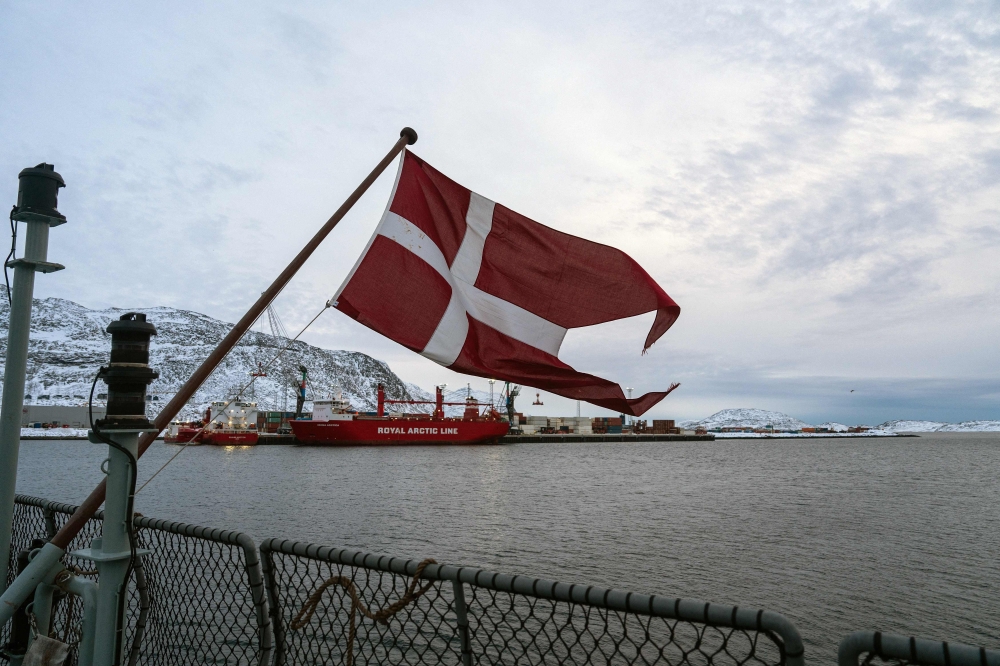 The Danish flag flies form the deck of the HDMS Knud Rasmussen Royal Danish Navy patrol vessel, moored at the harbour in Nuuk, Greenland on January 16, 2026. (Photo by Alessandro Rampazzo/ AFP)
