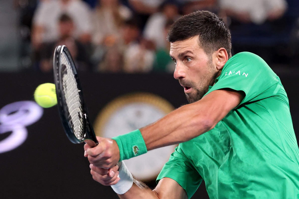 Serbia's Novak Djokovic hits a return to Spain's Pedro Martinez during their men's singles match on day two of the Australian Open tennis tournament in Melbourne on January 19, 2026. (Photo by DAVID GRAY / AFP)