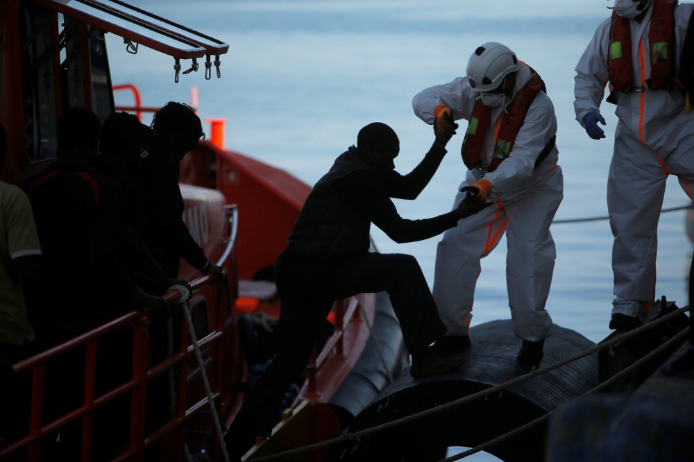 File photo: A migrant, part of a group intercepted aboard a dinghy off the coast in the Mediterranean Sea, is helped by a rescuer after arriving on a rescue boat at the port of Malaga, Spain June 22, 2018. REUTERS/Jon Nazca