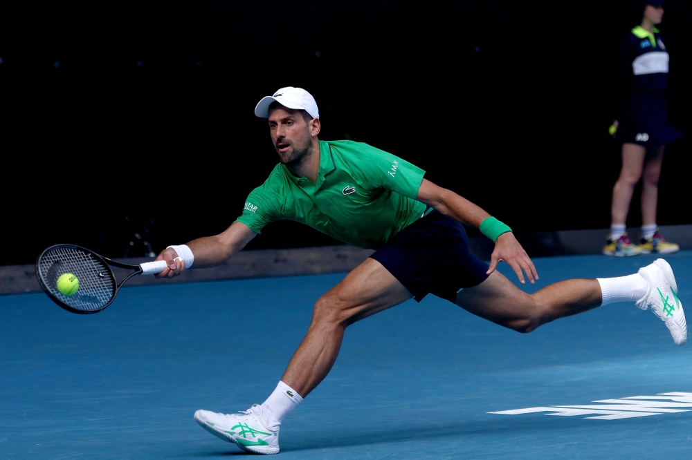 Serbia's Novak Djokovic hits a return to Italy's Lorenzo Musetti during their men's singles quarter-final match on day eleven of the Australian Open tennis tournament in Melbourne on January 28, 2026. (Photo by Izhar Khan / AFP) 
