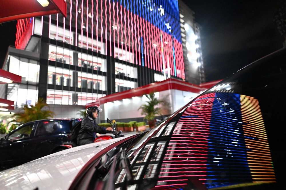 A Venezuelan flag is reflected in the windscreen of a car in Caracas on January 30, 2026. (Photo by Juan Barreto / AFP)
