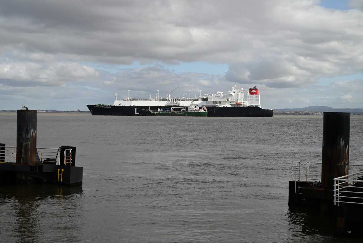 A small cargo ship next to an LNG tanker on the Tagus River off Lisbon, Portugal.