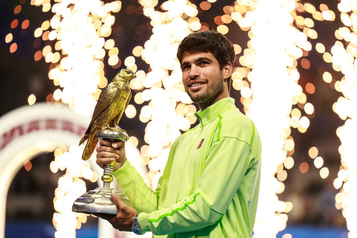 Spain's Carlos Alcaraz celebrates with the trophy after winning his men痴 singles final match against France's Arthur Fils at the Qatar Open tennis tournament in Doha on February 21, 2026. (Photo by Karim JAAFAR / AFP)

