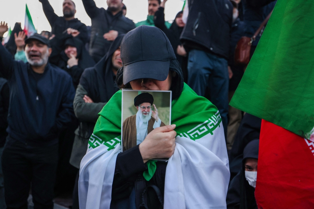 People mourn the death of Iran's supreme leader Ayatollah Ali Khamenei at a square in Tehran on March 1, 2026. (Photo by Atta Kenare / AFP)