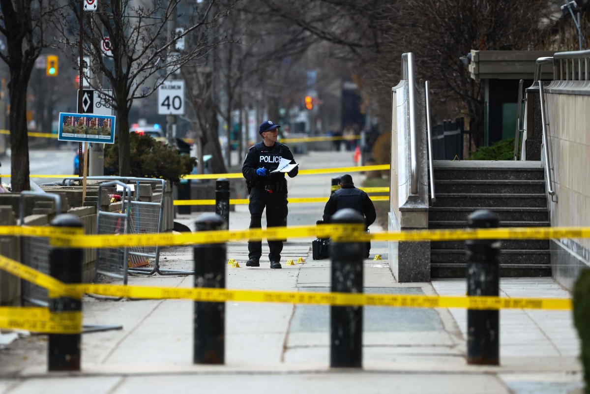 Toronto Police officers work around the scene of a shooting at the US Consulate in Toronto, Canada, on March 10, 2026. (Photo by Cole BURSTON / AFP)
