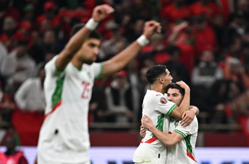 Morocco's forward #10 Brahim Diaz (R) celebrates scoring his team's first goal with Morocco's defender #02 Achraf Hakimi (2nd R) during the Africa Cup of Nations (CAN) quarter-final football match between Cameroon and Morocco at the Prince Moulay Abdallah stadium in Rabat on January 9, 2026. (Photo by Gabriel Bouys / AFP)