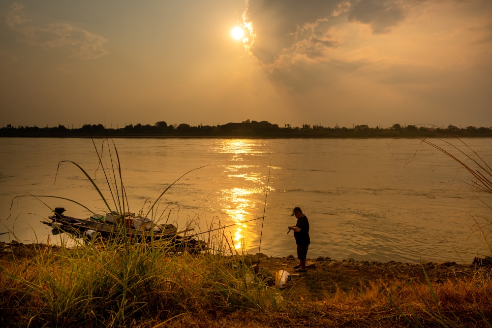 A man fishes along the Mekong River in Vientiane, Laos, March 22, 2026. (Photo by Kaikeo Saiyasane/Xinhua)