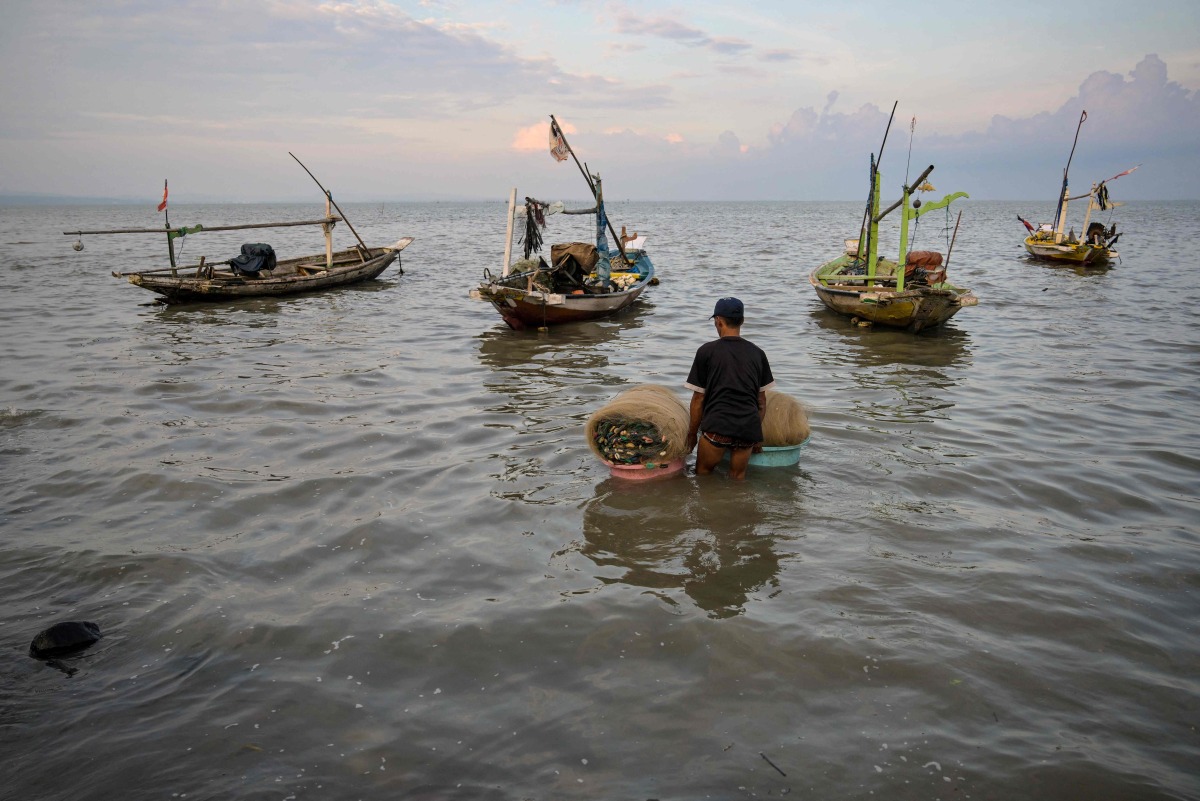A man prepares to go fishing in Surabaya on March 30, 2026. (Photo by JUNI KRISWANTO / AFP)