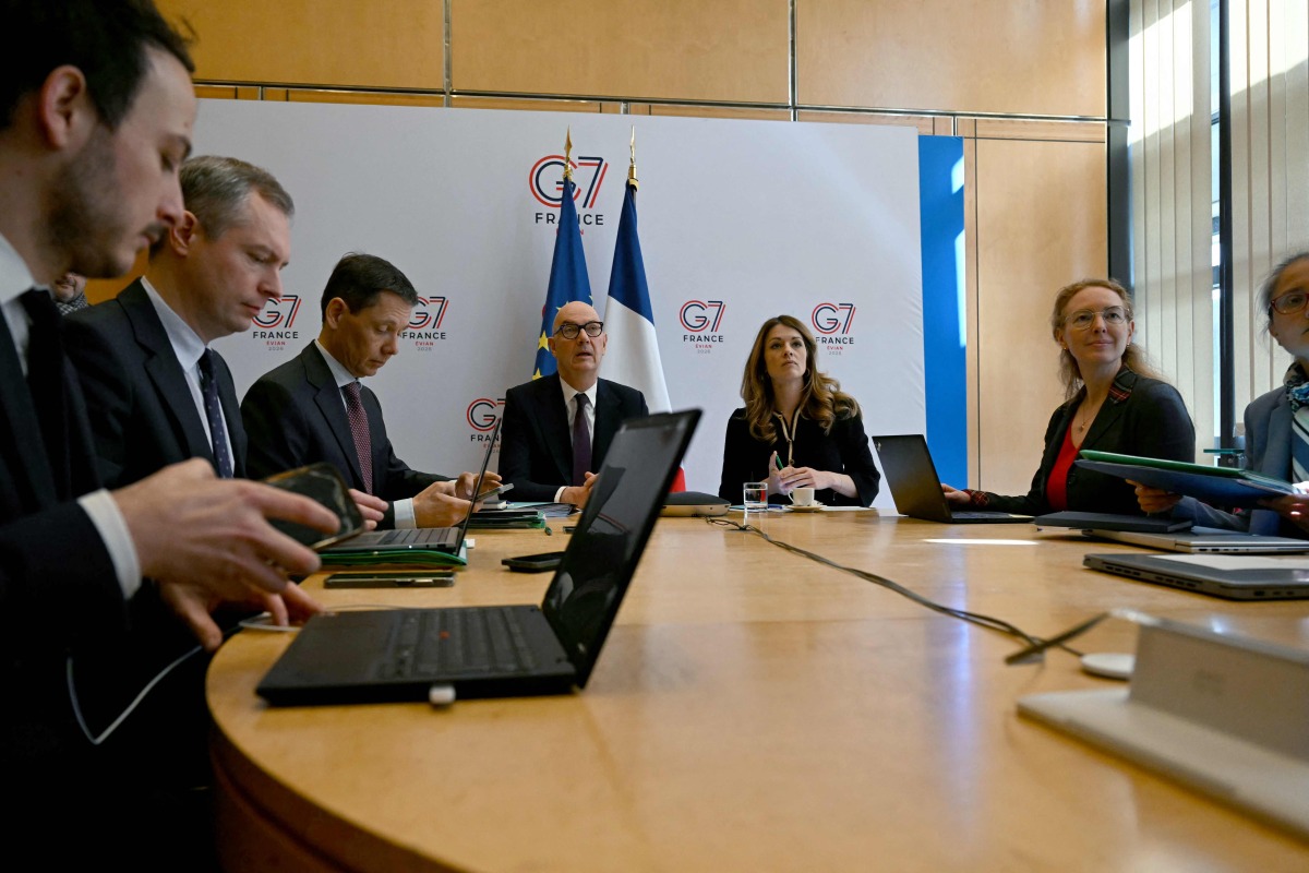France's Economy and Finance Minister Roland Lescure (C-L) and France's Government Spokesperson and Energy Minister Maud Bregeon (C-R) sit moments before hosting a videoconference with the G7 energy and finance ministers with central banks representatives at the French Economy minister in Paris on March 30, 2026. (Photo by Anna KURTH / AFP)