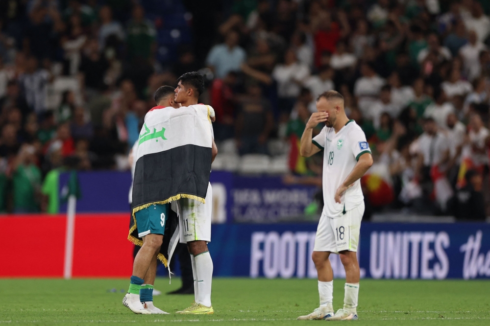 Iraq's forward #09 Ali Al-Hamadi (L) comforts Bolivia's forward #11 Fernando Nava (C) after the 2026 FIFA World Cup qualifiers final playoff football match between Iraq and Bolivia at the BBVA Stadium in Guadalupe, Nuevo Leon state, Mexico (Photo by Julio Cesar Aguilar / AFP)