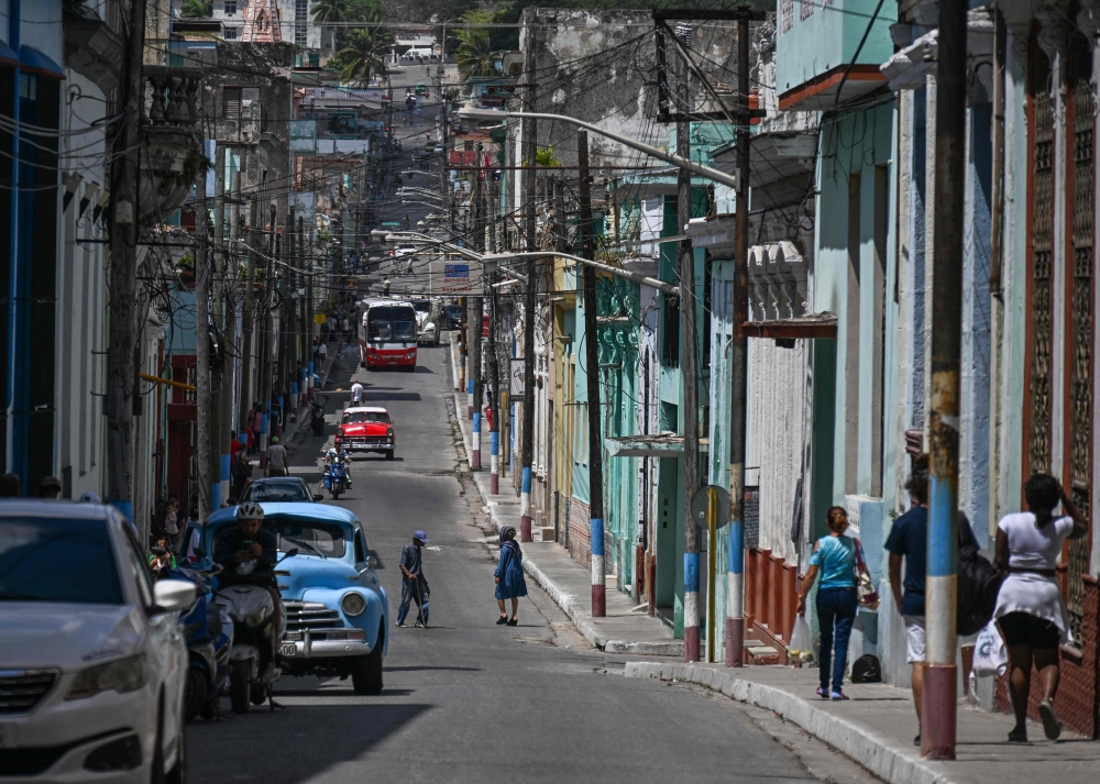 People walk down a street in Matanzas, Cuba, on March 31, 2026. (Photo by Yamil Lage / AFP)