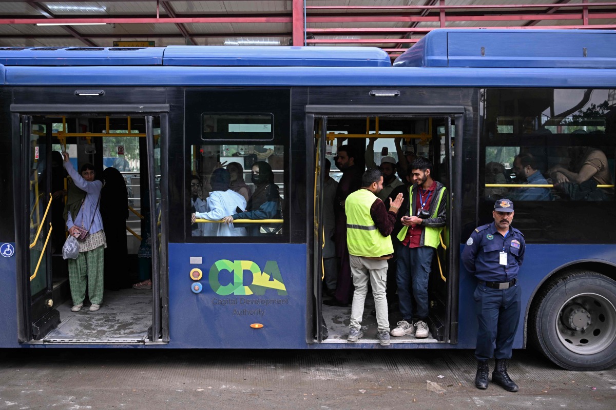 Passengers gather aboard a government bus at a bus stop in Islamabad on April 3, 2026. Photo by Farooq NAEEM / AFP