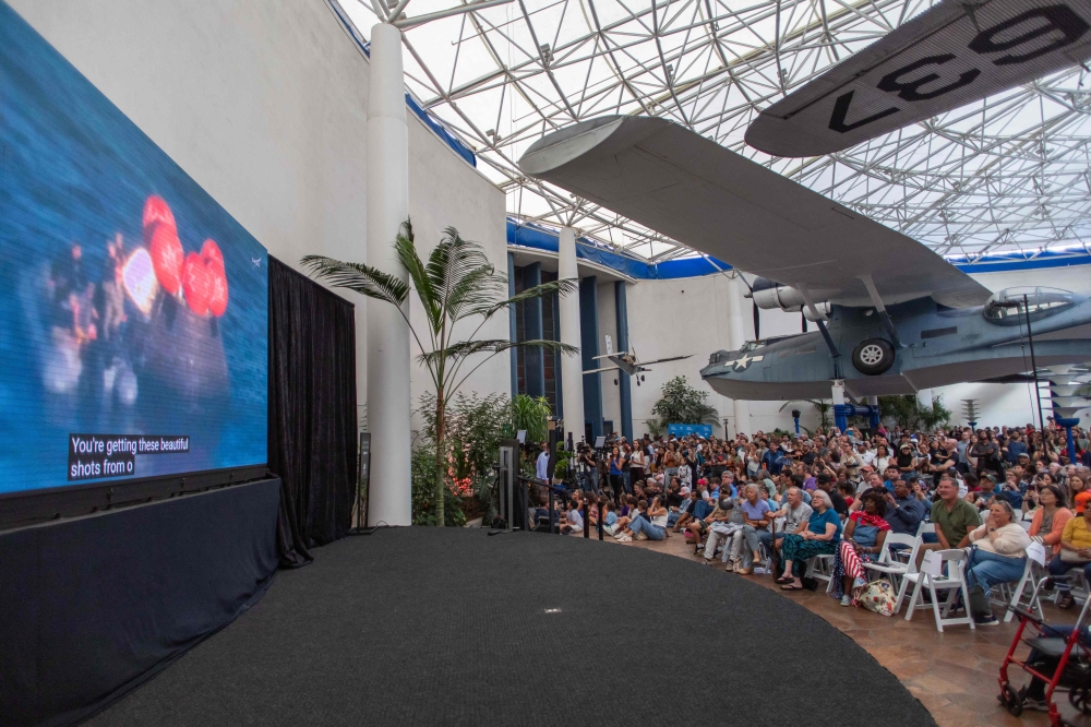 People watch a live broadcast of the return of the Artemis II crew members to Earth at the San Diego Air and Space Museum on April 10, 2026. (Photo by Apu Gomes / AFP)