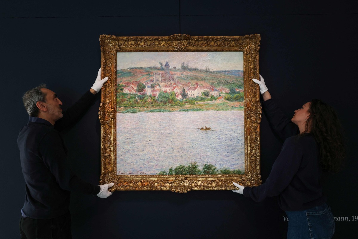 (FILES) Employees of the Sotheby's auction house handle the painting 