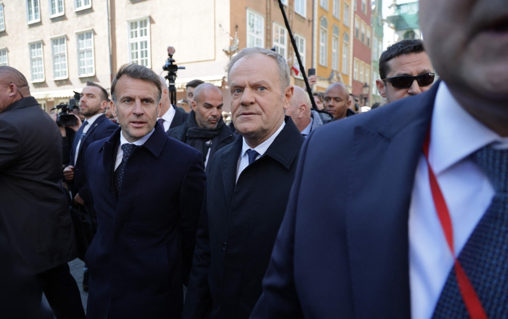 French President Emmanuel Macron (L) and Poland's Prime Minister Donald Tusk walk through Gdansk on April 20, 2026, during Macron's one-day-visit to Poland. (Photo by Ludovic MARIN / AFP)