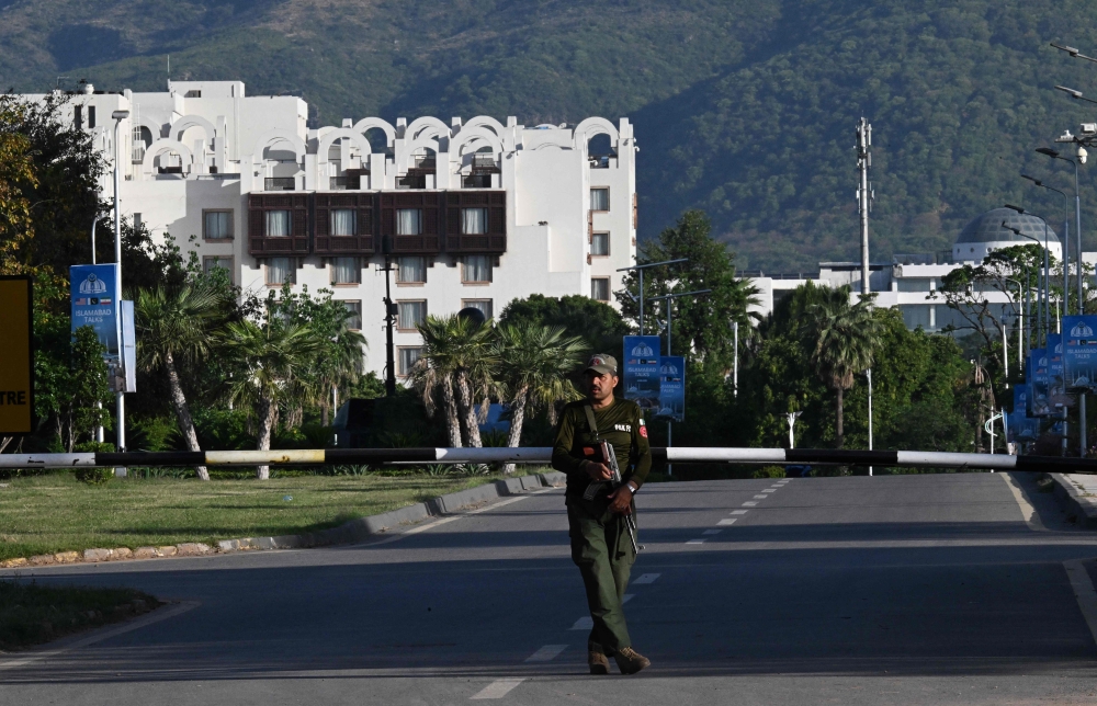 A policer officer stands guard near the Serena Hotel at the Red Zone area in Islamabad on April 22, 2026. (Photo by Aamir Qureshi / AFP)