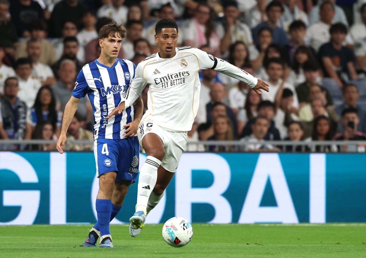 Real Madrid's English midfielder #05 Jude Bellingham fights for the ball with Alaves' Spanish midfielder #04 Denis Suarez during the Spanish league football match between Real Madrid CF and Deportivo Alaves at the Santiago Bernabeu stadium in Madrid on April 21, 2026. (Photo by Pierre-Philippe MARCOU / AFP)