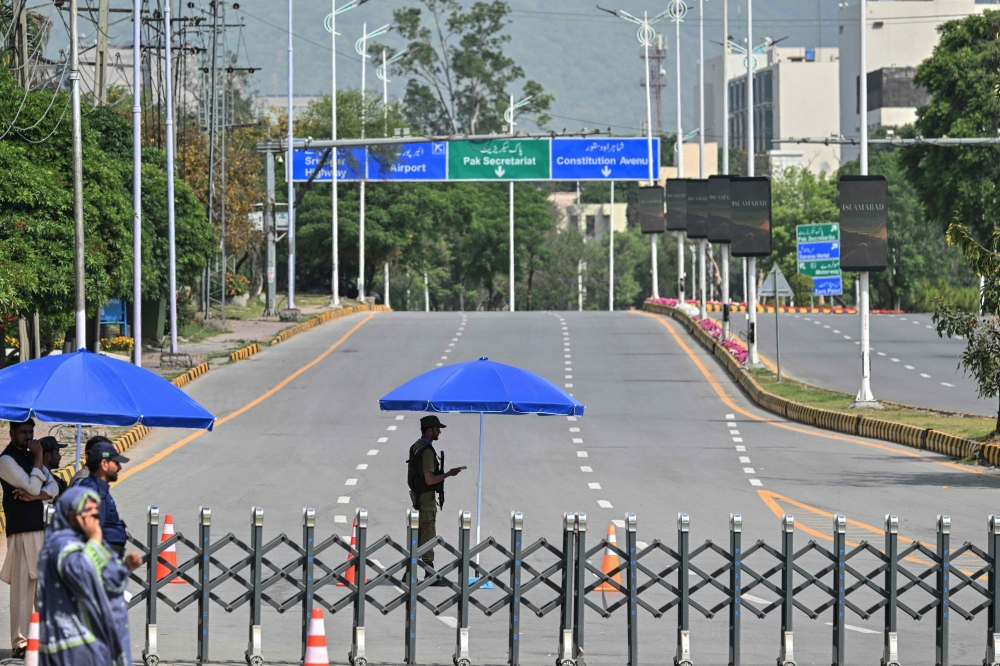 Security personnel stands guard at a closed road leading to the Serena Hotel in the Red Zone area of Islamabad on April 23, 2026. (Photo by Asif Hassan / AFP)
 