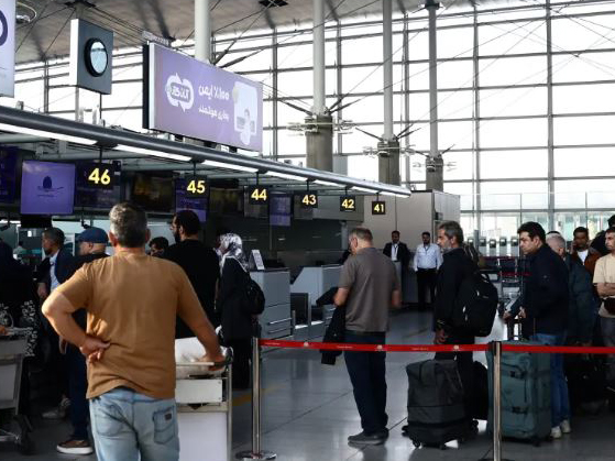 Passengers queue at the terminal hall after flights resumed at Imam Khomeini International Airport, amid a ceasefire between the US and Iran, in Tehran, Iran [Majid Asgaripour/WANA via Reuters]
