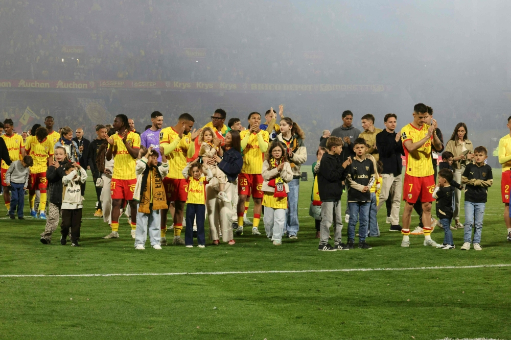 Lens players and their families greet the fans at the end of the French L1 football match between RC Lens and FC Nantes after qualifying for the Champions League. (Photo by Francois LO PRESTI / AFP)