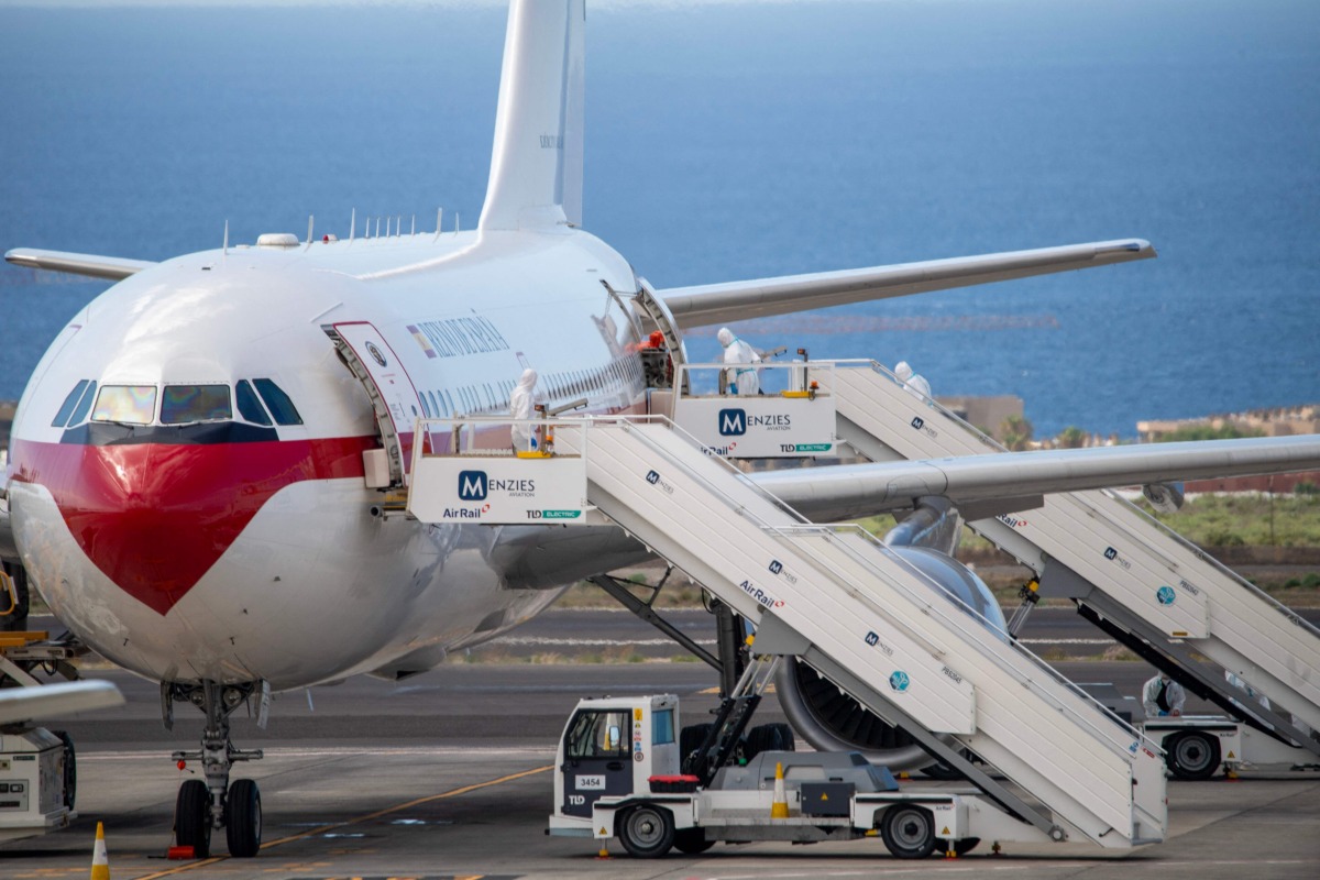 A Spanish evacuee wearing a white hazmat protective suit boards the rear door of a Spanish air force Airbus A310 plane at the Tenerife Sur-Reina Sofia airport after being evacuated from the Dutch flagged hantavirus-stricken cruise ship MV Hondius which anchored at the industrial port of Granadilla de Abona on the island of Tenerife in Spain's Canary Islands on May 10, 2026. Photo by Antonio Sempere / AFP
