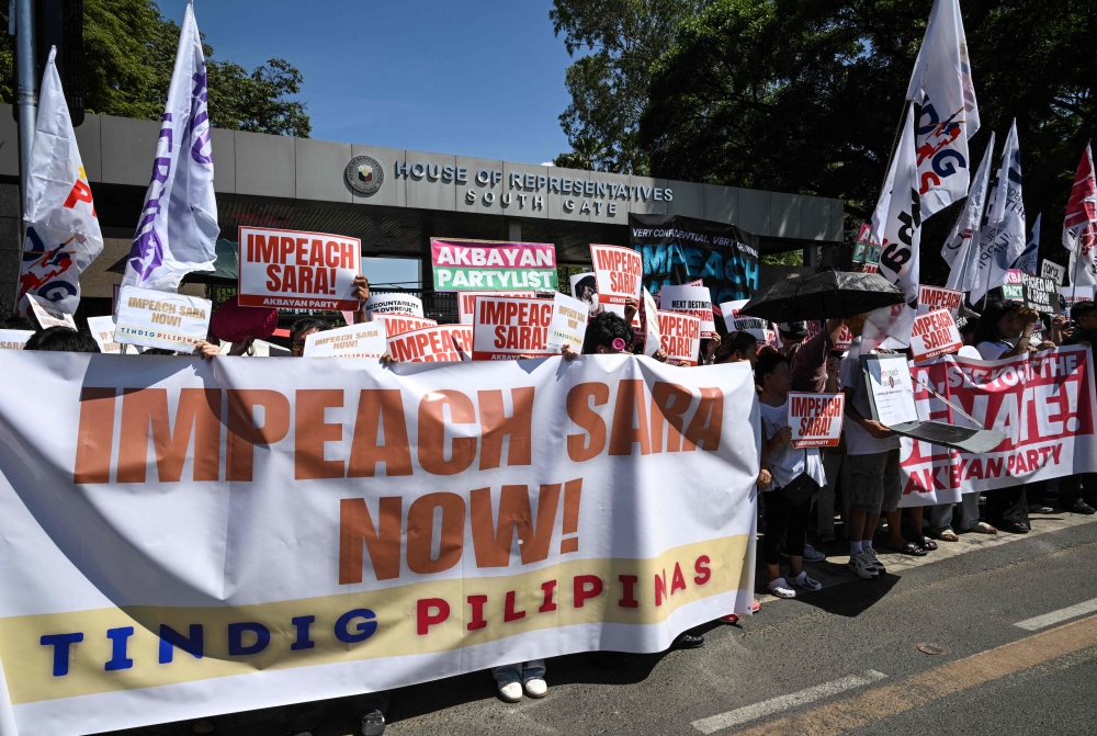 Protesters holding banners protest in support of the impeachment of Philippine Vice-President Sara Duterte in front of the House of Representatives in Quezon City, Metro Manila  (Photo by Ted  Aljibe / AFP)
