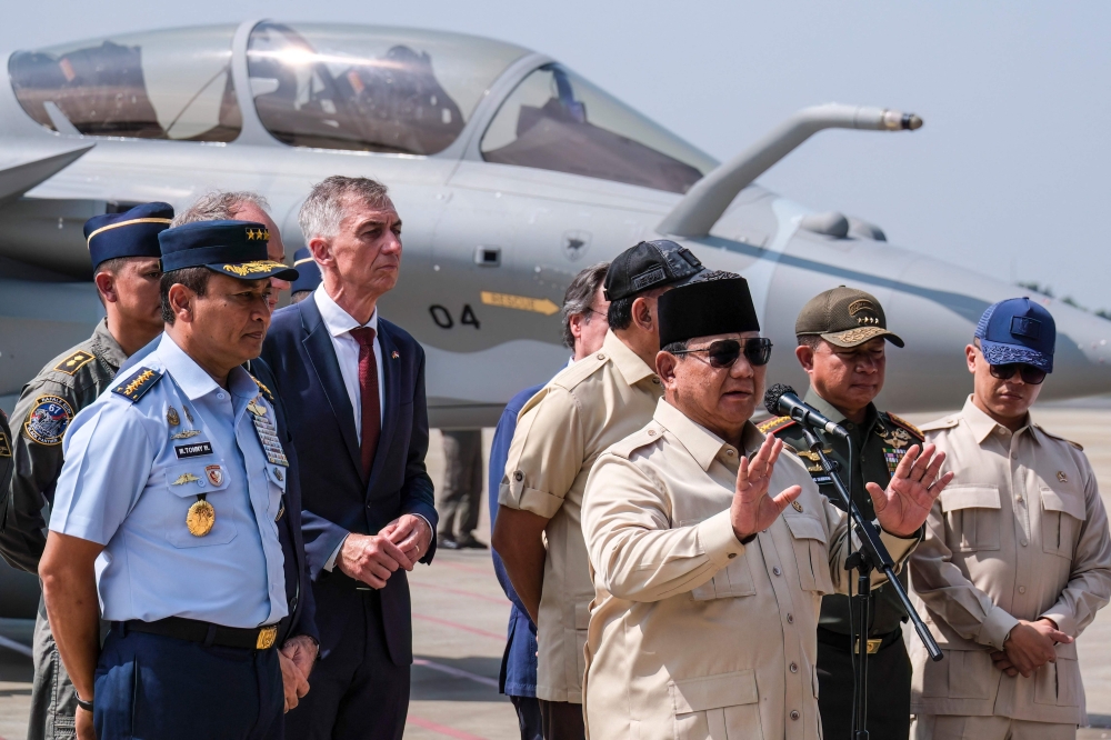Indonesian President Prabowo Subianto (front) delivers a statement to journalists during a ceremony to hand over six new Rafale jet fighters, four Dassault Falcon 8X aircrafts and one Airbus A400M Atlas aircraft to the Indonesian Air Force at Halim Perdanakusuma Air Force Base in Jakarta.. (Photo by Bay Ismoyo / AFP)