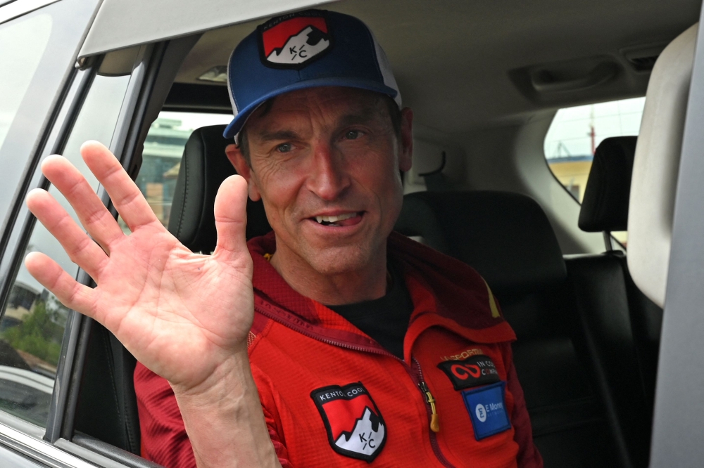 British climber Kenton Cool waves from a car upon his arrival at the airport in Kathmandu. (Photo by Prakash Mathema / AFP)