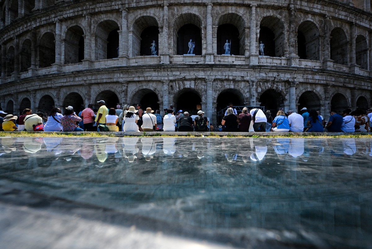 People sit in the shade of the Colosseum during an early-season heatwave in Rome on May 28, 2026. Photo by TIZIANA FABI / AFP