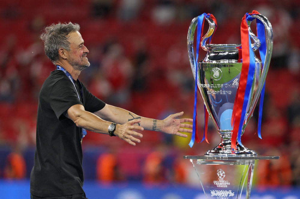 Paris Saint-Germain's Spanish head coach Luis Enrique walks to hug the trophy after winning the UEFA Champions League final football match between Paris Saint-Germain (PSG) and Arsenal FC at the Puskas Arena in Budapest on May 30, 2026. (Photo by Odd Andersen / AFP)