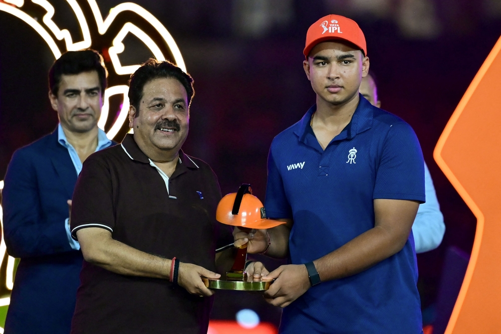 Rajasthan Royals' Indian cricket player Vaibhav Sooryavanshi (R) is awarded the 