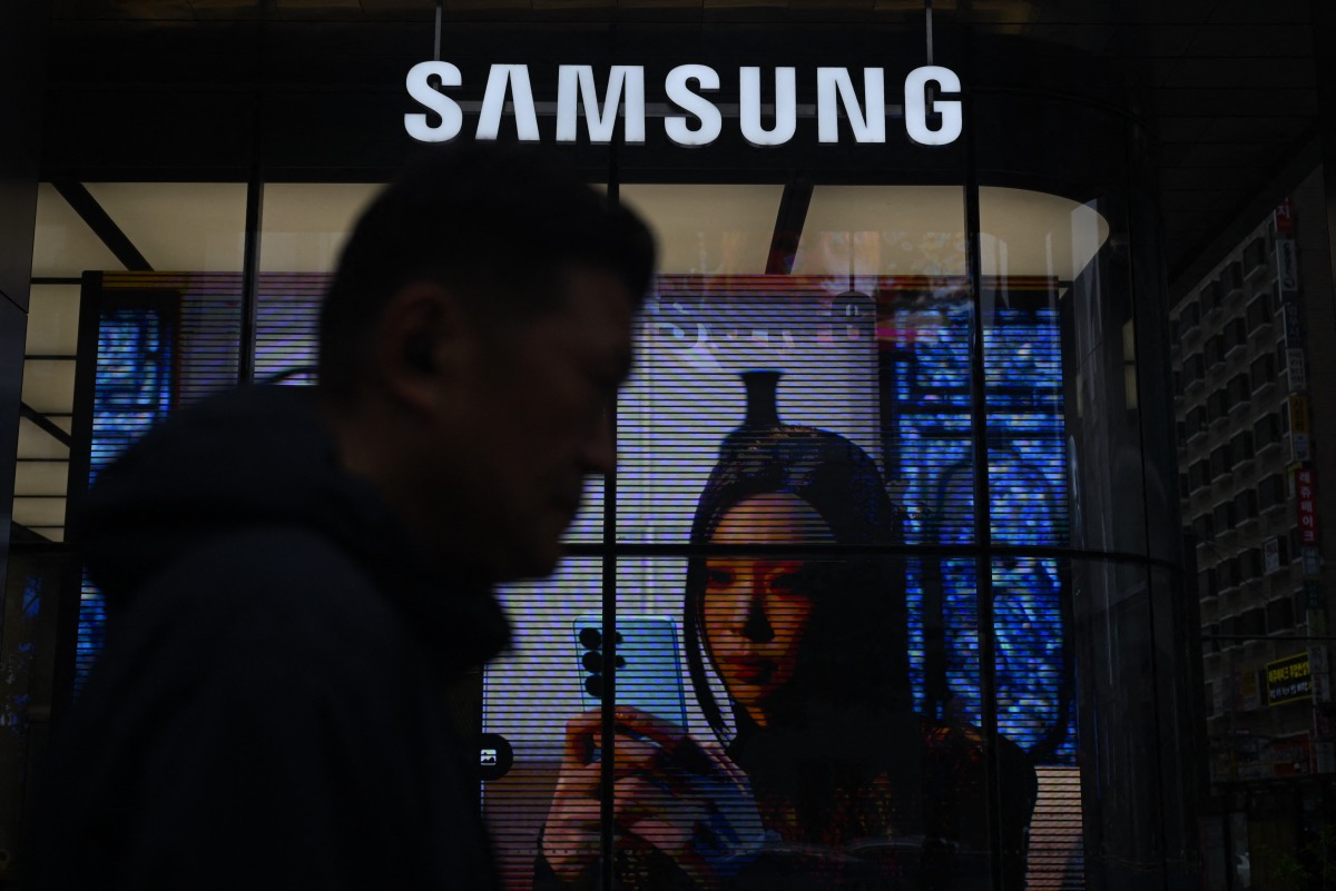 A man walks past a Samsung store in Seoul on May 28, 2026. (Photo by Pedro Pardo / AFP)