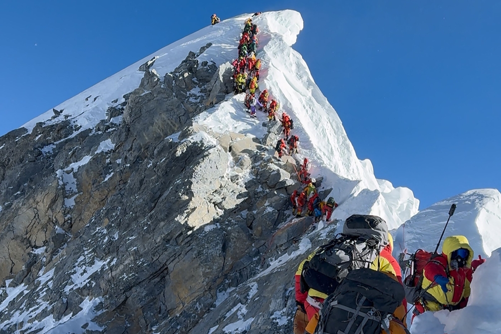(Files) This photograph taken on May 20, 2026, shows mountaineers climbing a slope lined up during their ascent from the Hillary Step to summit Mount Everest in Nepal. (Photo by Furte Sherpa / AFP)